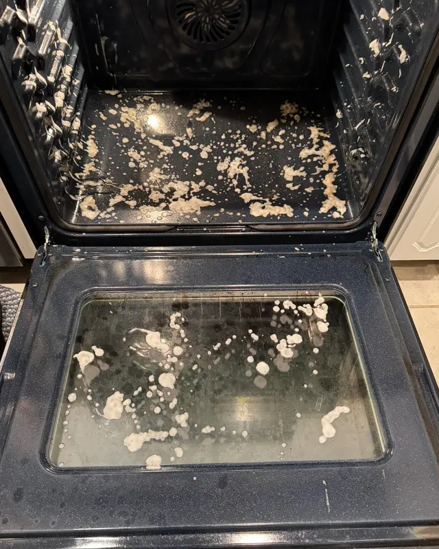 Inside of an oven with baked-on grease and spills on the racks and door glass.